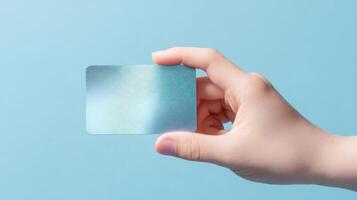 The Clear Card Held in a Hand Against a Minimalistic Blue Background. photo