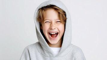 A young boy wearing a hoodie and laughing photo
