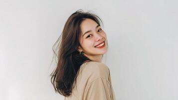 A woman smiling while standing in front of a white background photo