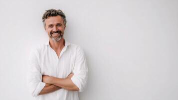 A man with a beard and white shirt standing in front of a white wall photo