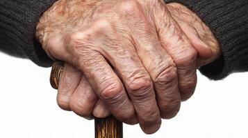 An elderly person's hands holding a walking stick photo