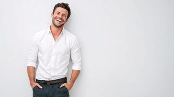 A man is smiling while standing against a white wall photo