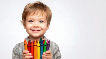 A young boy holding a bunch of crayons photo