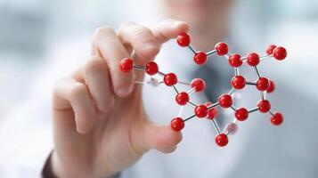 A person holding a red molecule model photo
