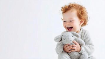 A baby laughing with a stuffed animal photo