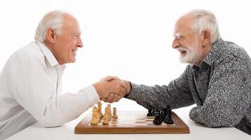 Two older men shaking hands while playing chess photo