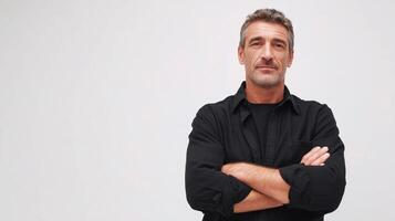 A man in a black shirt standing with his arms crossed photo