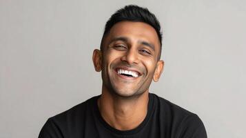 A man smiles while wearing a black shirt photo