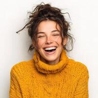 A woman is laughing and smiling in a yellow sweater photo
