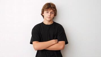 Teenage boy with arms crossed standing against white wall photo