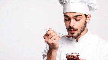 A man in a chef hat is eating a piece of jam photo