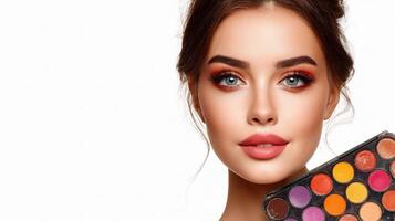 Beautiful woman holding makeup palette and looking at camera photo