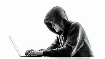 A person in a hoodie is using a laptop photo