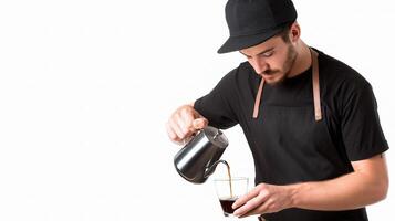 A man in a black shirt pouring coffee into a cup photo