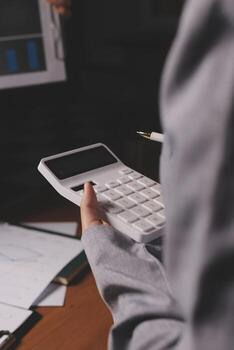 A person is using a calculator to do some math photo