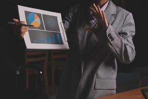 A woman in a suit holding a piece of paper with graphs on it photo