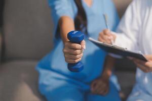A woman in scrubs holding a dumbbell while sitting on a couch photo