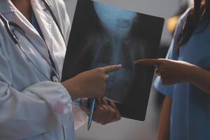 A doctor is pointing to an x - ray image photo