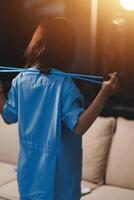 A woman in a blue shirt is holding a rope photo