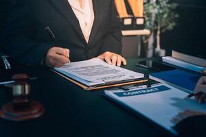 A man in a suit is signing a document photo