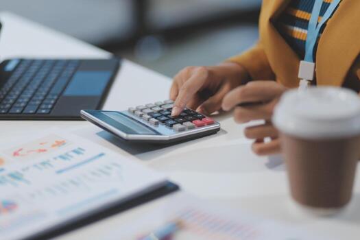 A woman is using a calculator to calculate the cost of a coffee photo