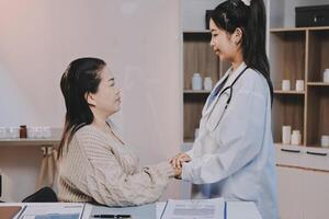 A woman is shaking hands with a doctor photo
