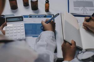 Two doctors are working on a paper with a calculator photo