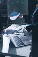 Two business people at a table with papers and laptops photo