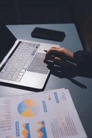 A person is using a laptop with a graph on it photo