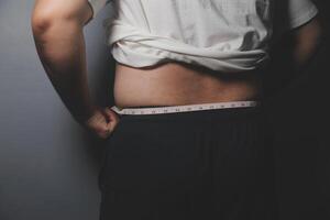 A man with a measuring tape on his stomach photo