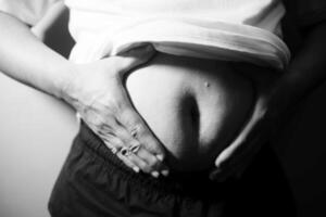 A black and white photo of a man holding his stomach