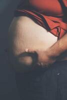 A pregnant woman with her hands on her belly photo