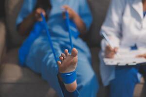 A doctor is holding a foot with blue tape photo