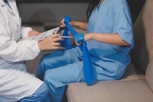 A woman in scrub clothes is sitting on a couch with a doctor photo