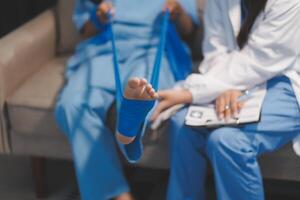A doctor is holding a foot with a bandage on it photo