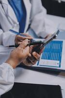 A doctor is using a tablet while another person looks at it photo