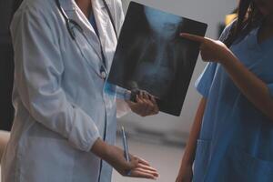 A doctor and a nurse are looking at an x - ray photo