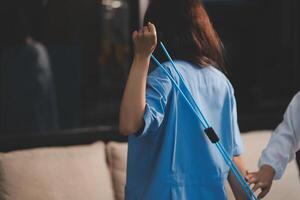 A woman in a blue shirt is holding a stick photo