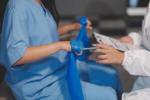 A woman in scrubs is holding a blue bandage photo