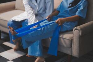 A woman sitting on a couch with a doctor holding her leg photo