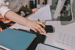 A person is working at a desk with a pen and paper photo