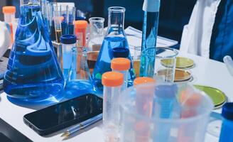 A table with many different types of liquids and test tubes photo