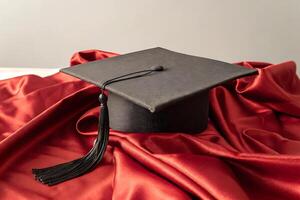 a graduation cap sits on top of a red cloth photo
