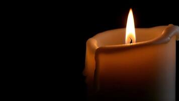 Close Up View of a White Dripping Wax Candle with a Bright Flame in Darkness photo