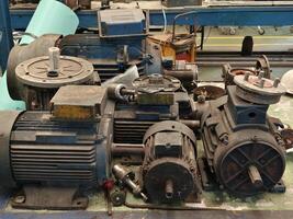 Stack of Old Disassembled Electric Motors on a Workbench in a Workshop photo