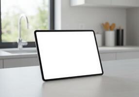 A white tablet on a kitchen counter with a blank screen photo