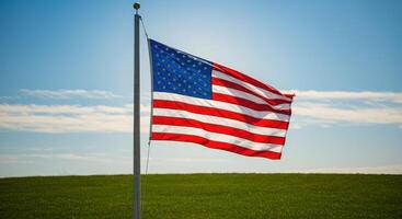 An american flag flying in the wind on a grassy field photo