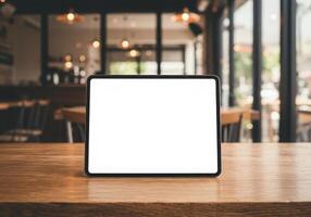 Tablet mockup on wooden table in cafe photo
