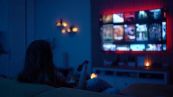 Woman Relaxing at Home Watching a Movie at Night While Eating Popcorn in a Cozy Living Room video
