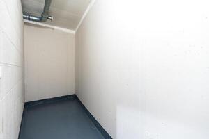 Empty basement storage room with industrial ventilation and concrete walls photo